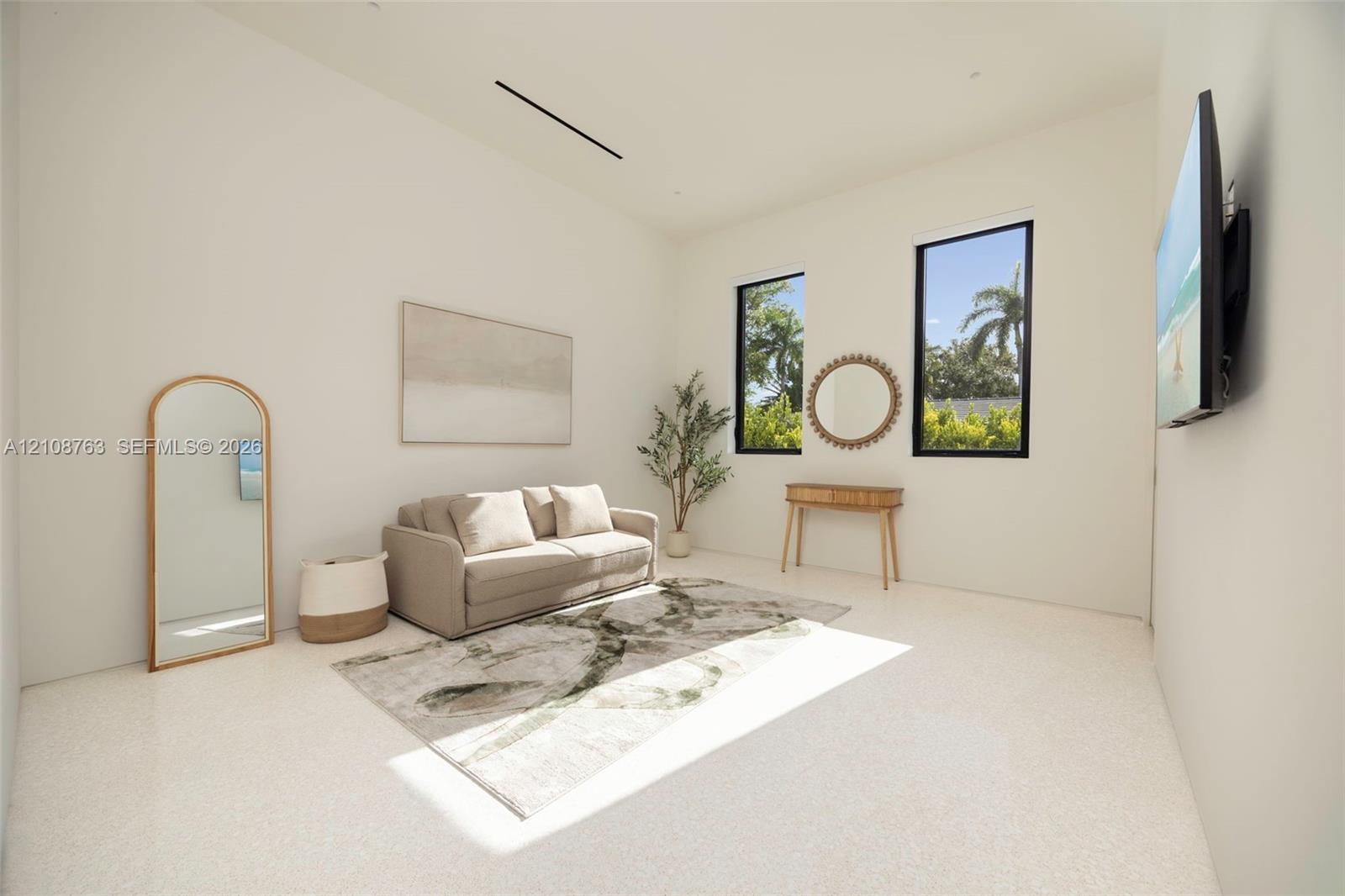 Neutral interior featuring high ceilings, light-toned terrazzo flooring, and black-framed windows