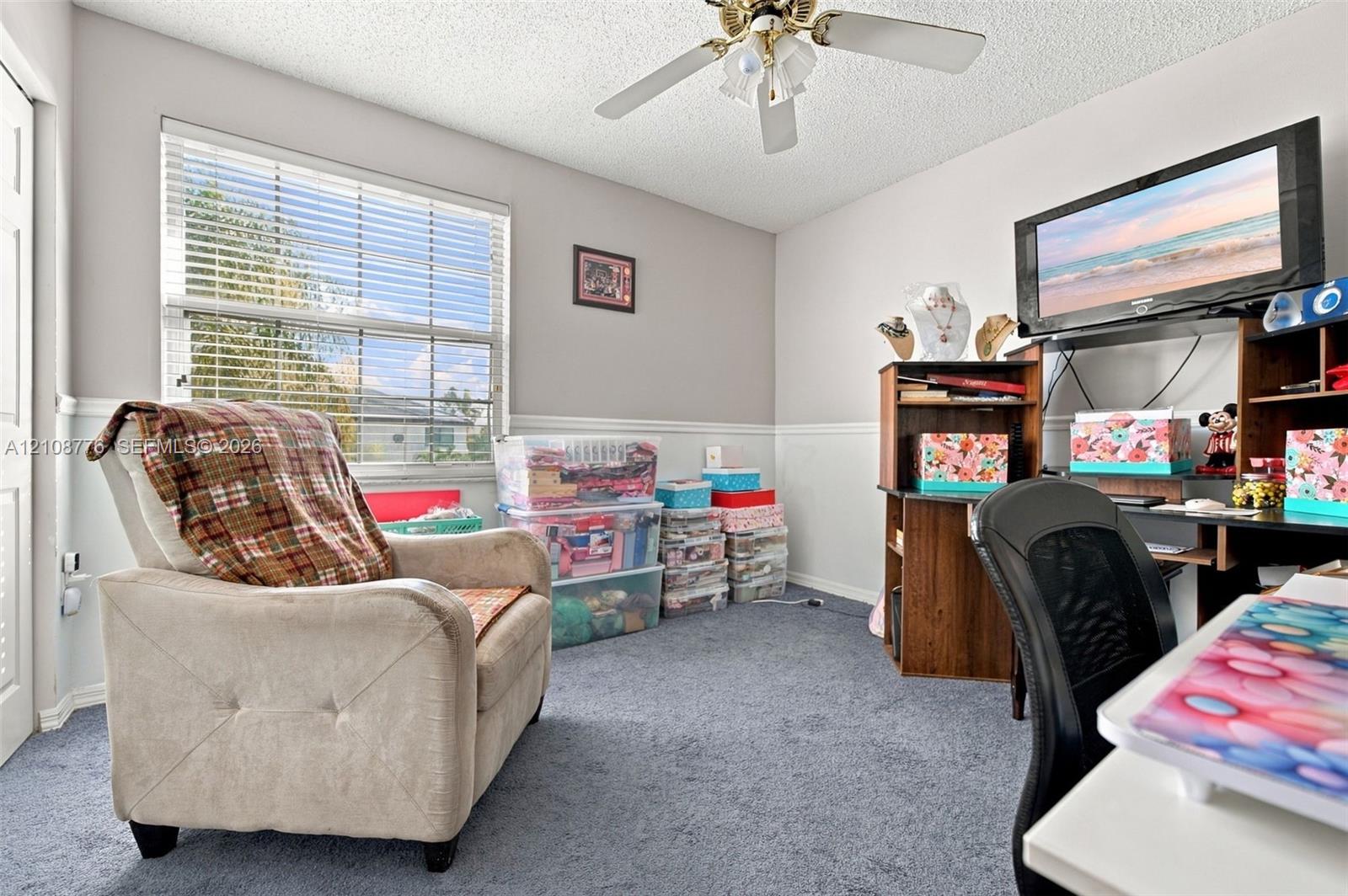 Room featuring wall-to-wall carpeting, horizontal window blinds, chair rail molding, and a ceiling fan with integrated light fixture
