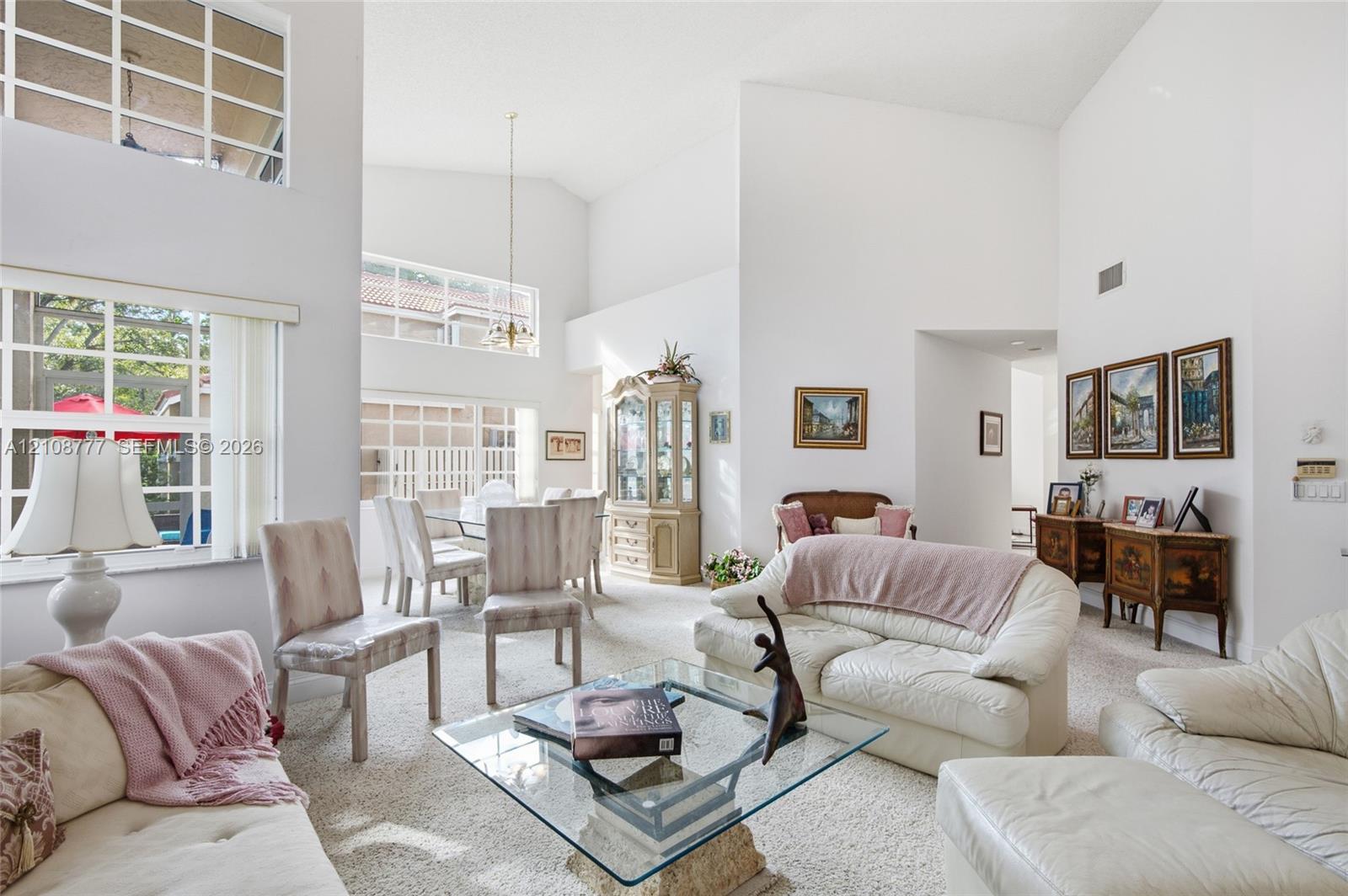 Vaulted ceilings, expansive multi-pane windows, and a suspended dining area light fixture