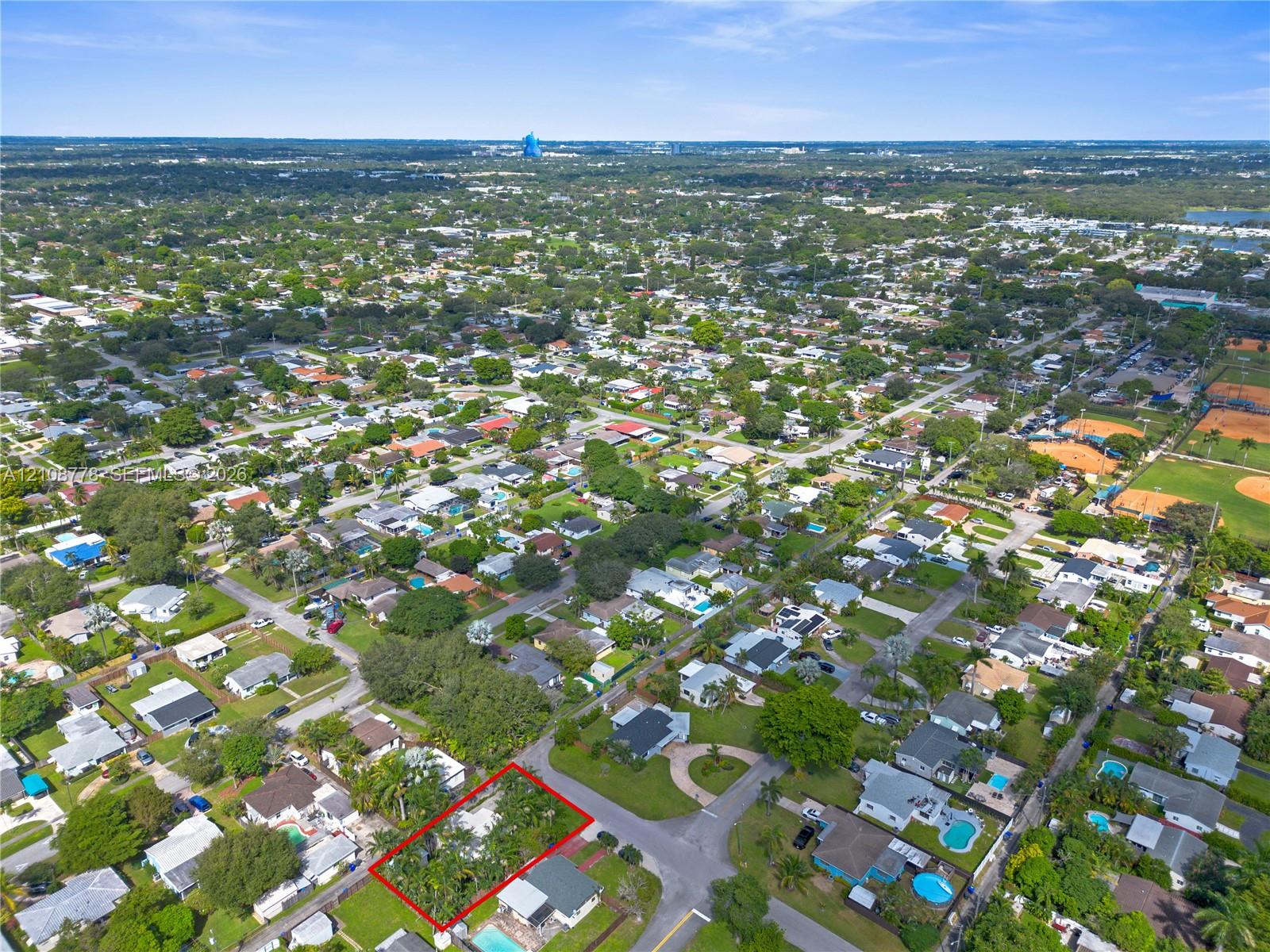 Aerial perspective of a corner lot property featuring established mature trees and perimeter greenery