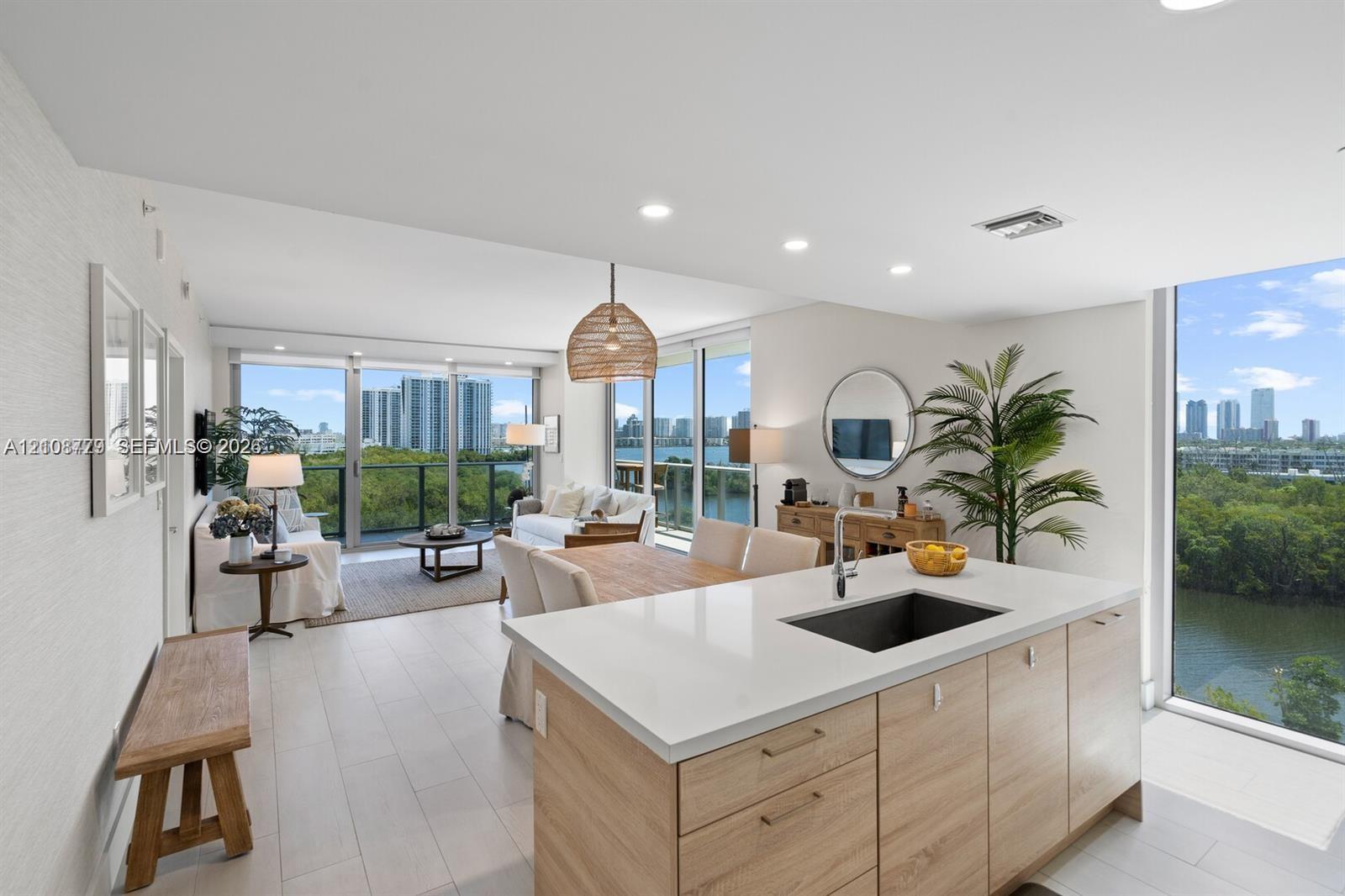 Open-concept kitchen featuring an island with wood-finish cabinetry, quartz countertops, and a rectangular undermount sink Open-concept kitchen featuring an island with wood-finish cabinetry, quartz countertops, and a rectangular undermount sink