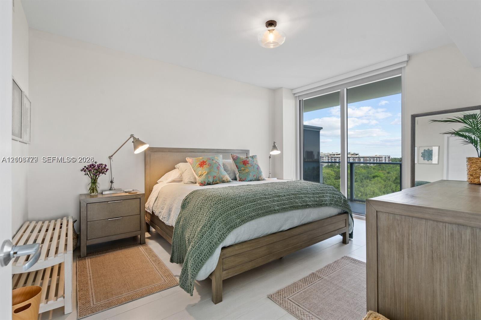 Floor-to-ceiling sliding glass doors, neutral tile flooring, glass globe ceiling lighting, and private balcony access