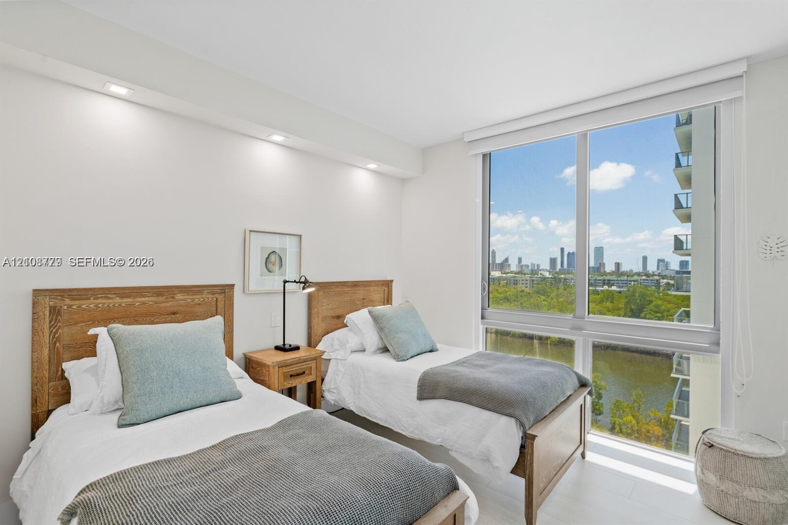 Floor-to-ceiling windows featuring urban and water scenery, recessed ceiling lighting, and smooth-finish flooring