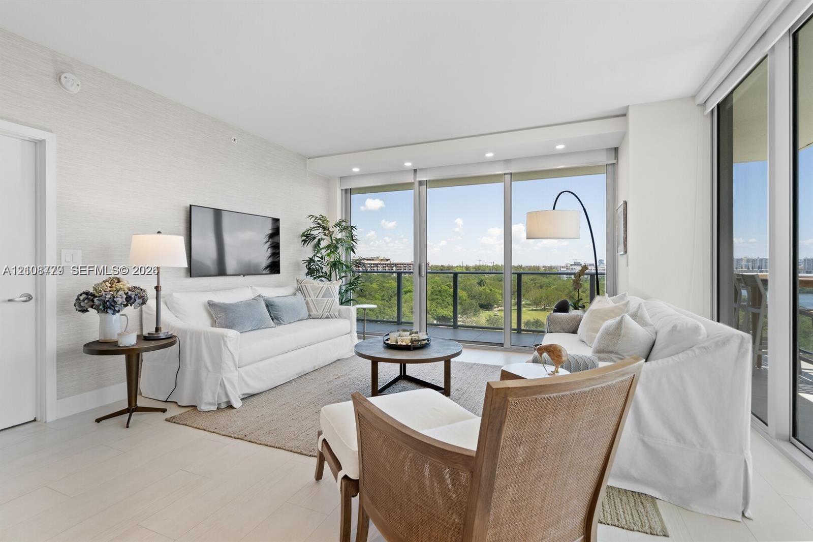 Living area featuring floor-to-ceiling glass sliding doors, recessed lighting, textured wall finishes, and light-toned tile flooring Living area featuring floor-to-ceiling glass sliding doors, recessed lighting, textured wall finishes, and light-toned tile flooring