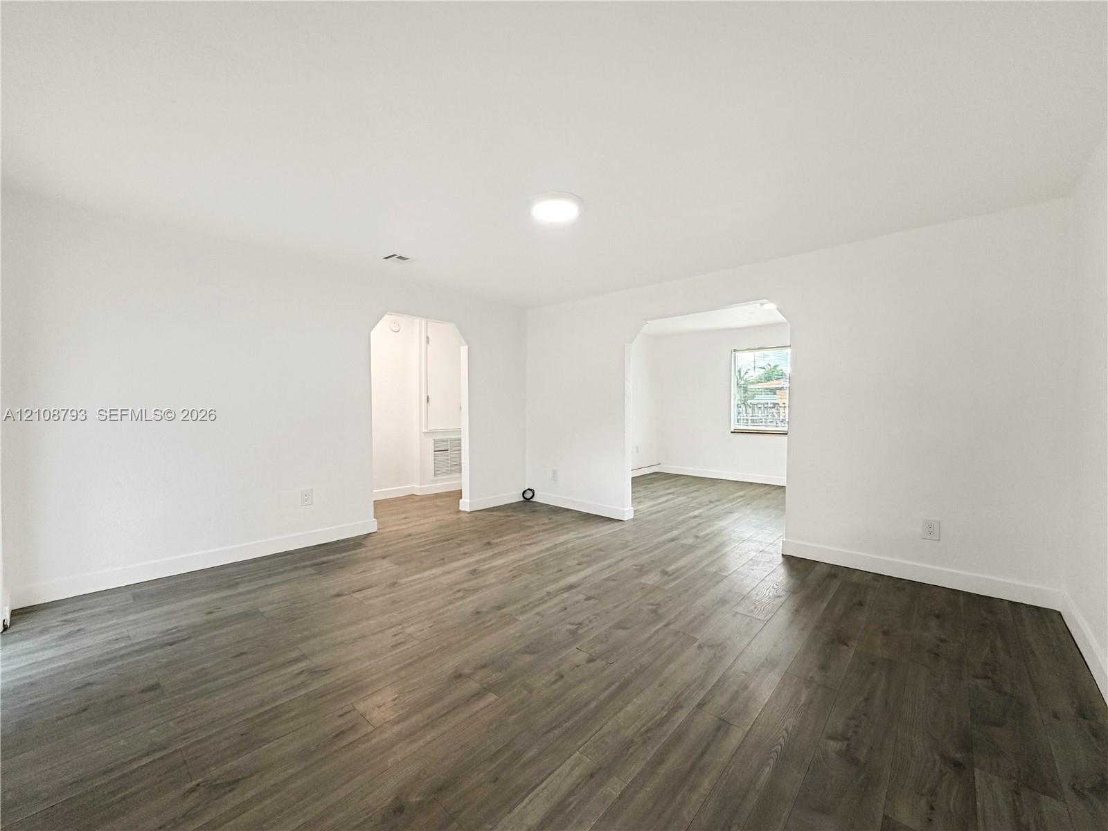 Interior space featuring wood-finish flooring, recessed ceiling lighting, and arched doorways