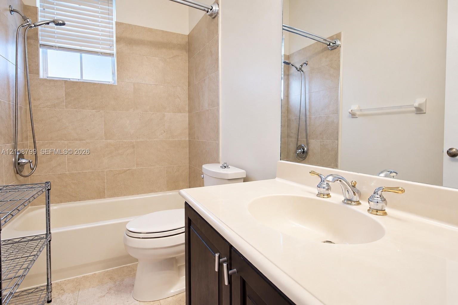 Bathroom featuring a vanity with a solid-surface countertop, integral sink, and dual-handle faucet