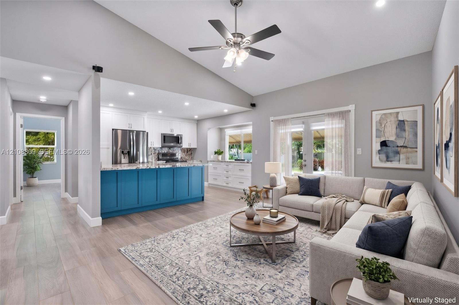 Vaulted ceilings, wood-finish flooring, recessed lighting, central kitchen island with cabinetry, and double glass doors