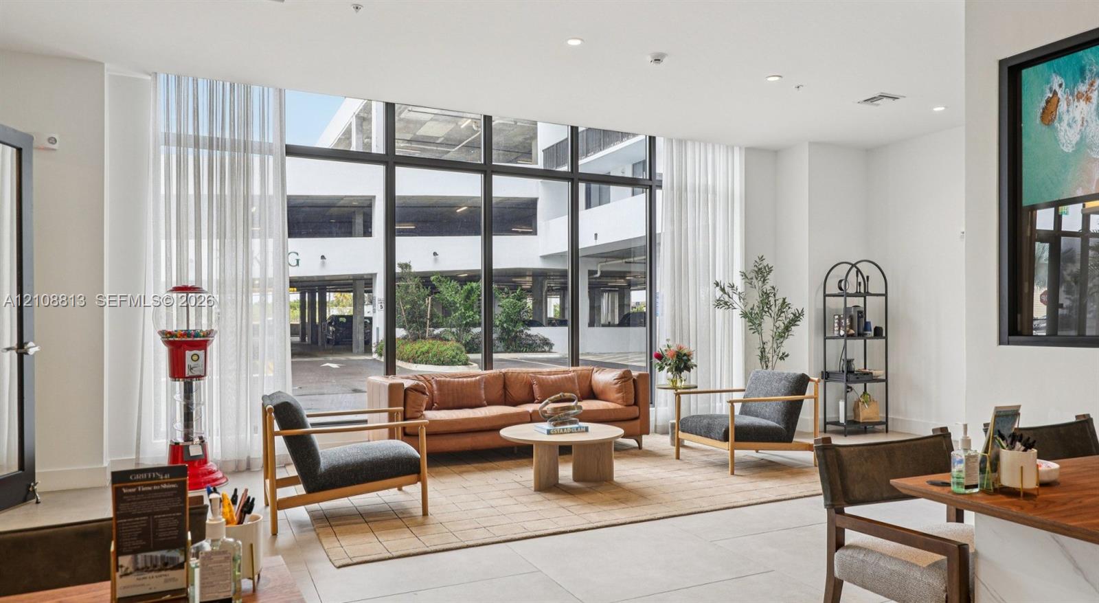 Floor-to-ceiling windows with dark metal framing and neutral-toned oversized floor tile