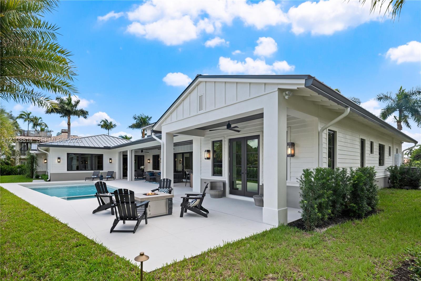 Covered patio featuring board and batten siding, recessed ceiling lighting, attached ceiling fan, and concrete hardscaping surrounding an in-ground swimming pool