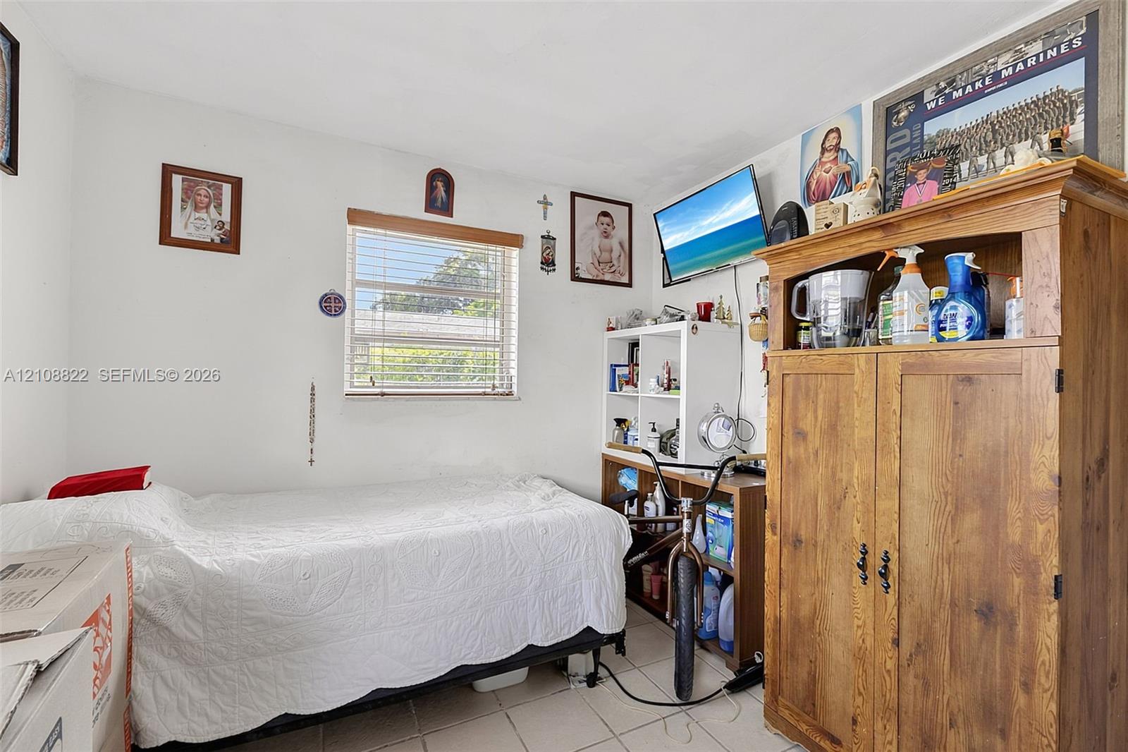 Single-pane window with wood-finish blinds and neutral tile flooring