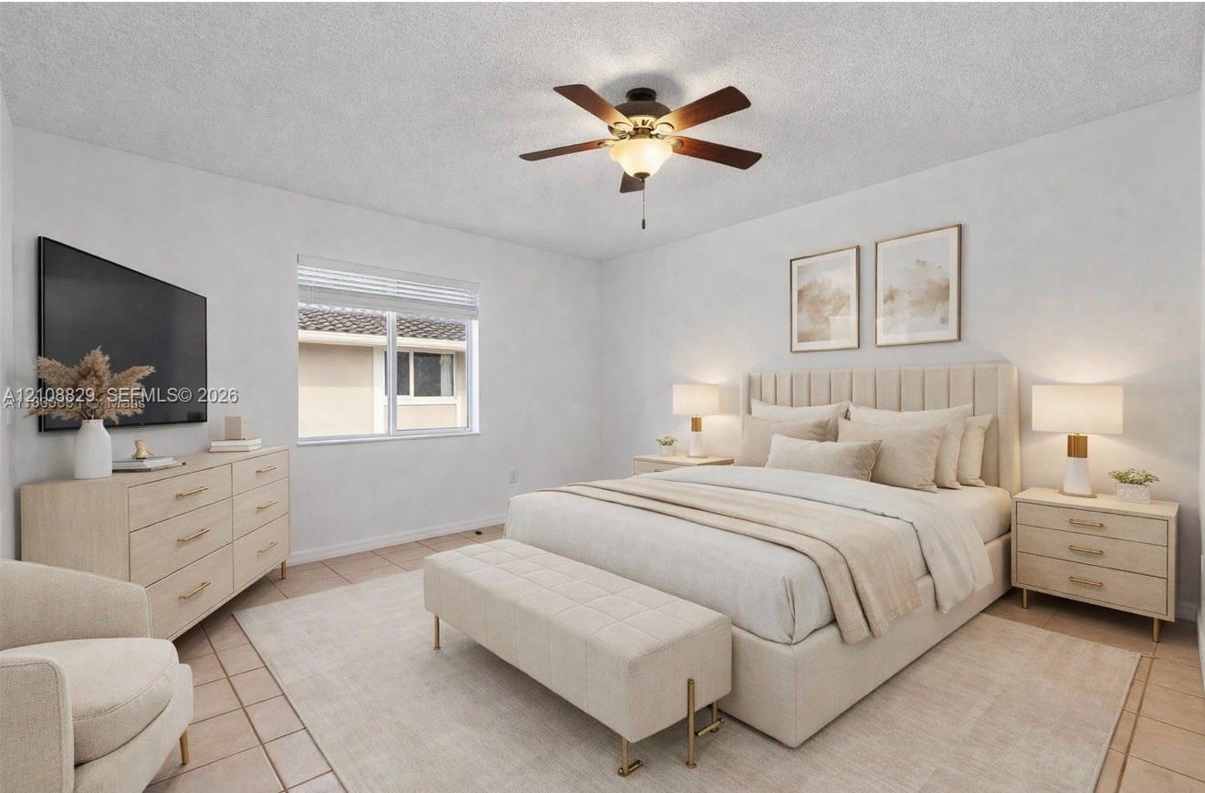 Spacious interior room featuring tile flooring, a textured ceiling, a central ceiling fan with an integrated light fixture, and a large horizontal window