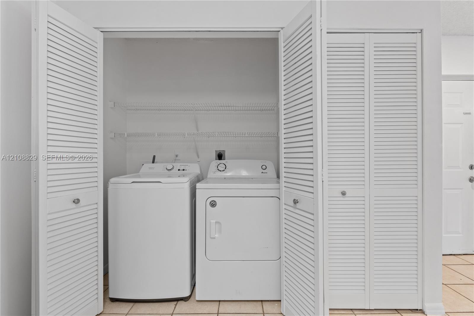 Laundry closet featuring white louvered bifold doors and wire shelving