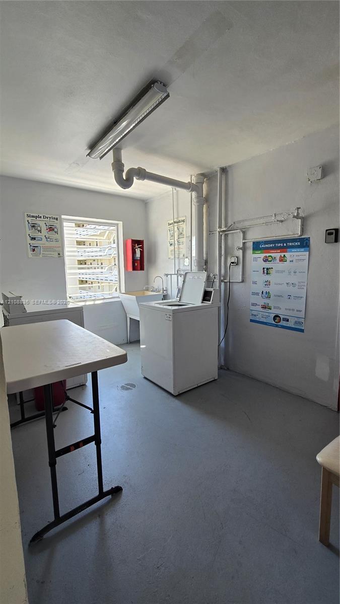 Utility area featuring an integrated wash basin, exposed industrial-style lighting, and a window providing natural light