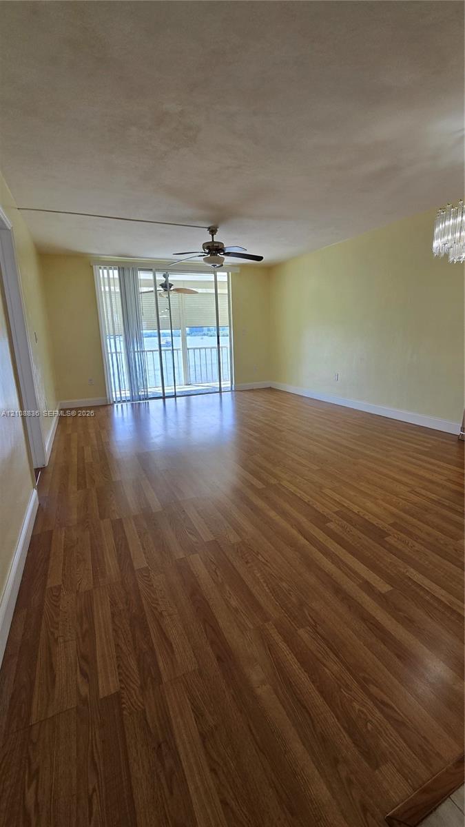 Wood-finish flooring, ceiling fan, sliding glass door, and crystal-style chandelier