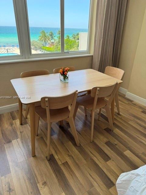 Large multi-pane windows featuring an ocean and coastline backdrop, complemented by wood-finish flooring