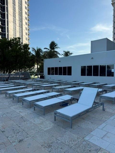 Outdoor terrace featuring natural stone tile flooring and large-format exterior windows