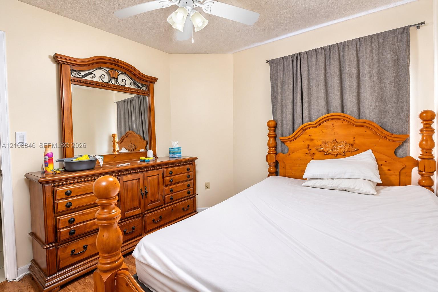 White ceiling fan with integrated three-light fixture and wood-finish flooring