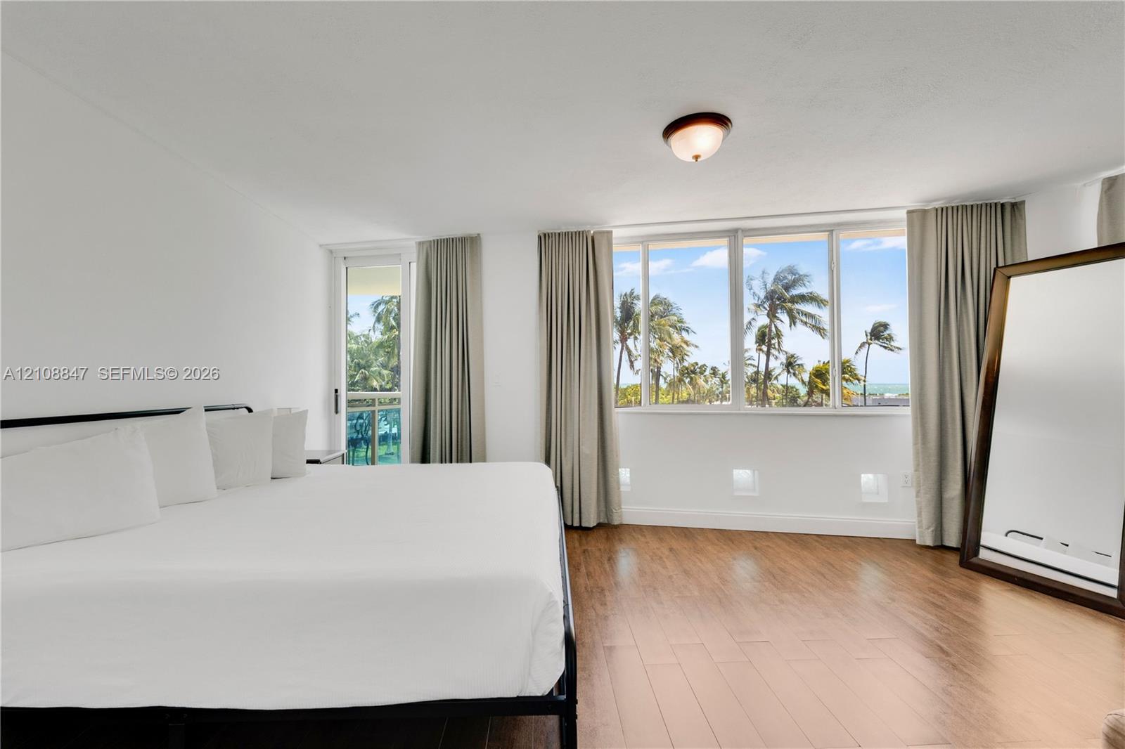 Wood-finish flooring, floor-to-ceiling windows, access to a private balcony, and flush-mount ceiling lighting