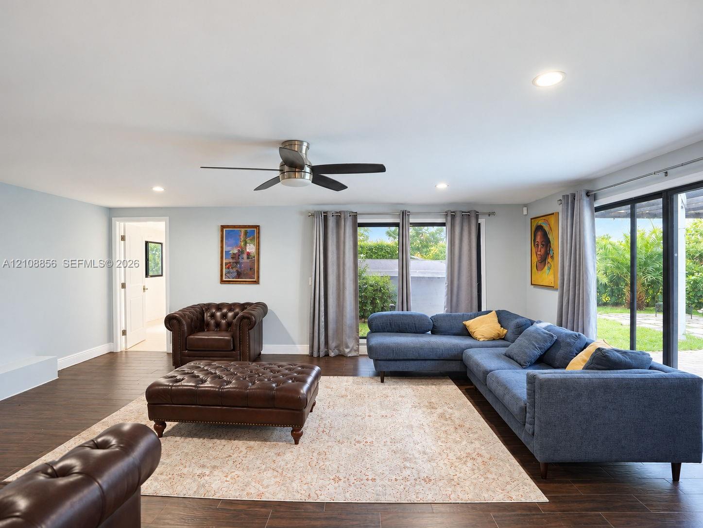Spacious room featuring wood-finish tile flooring, recessed lighting, a ceiling fan, and large sliding glass doors