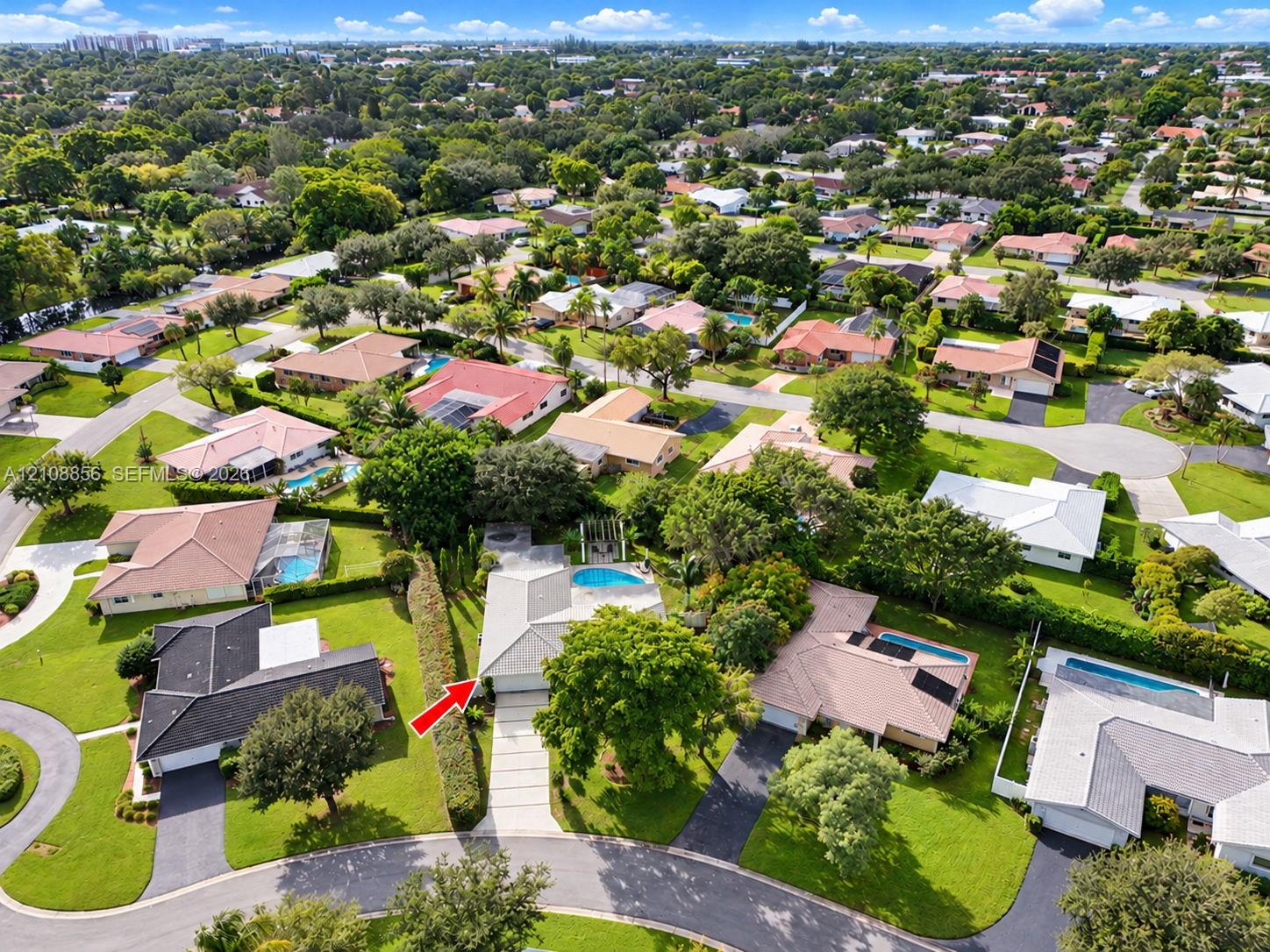 Aerial perspective of property featuring a concrete driveway, multi-paneled roof, and an in-ground swimming pool Aerial perspective of property featuring a concrete driveway, multi-paneled roof, and an in-ground swimming pool
