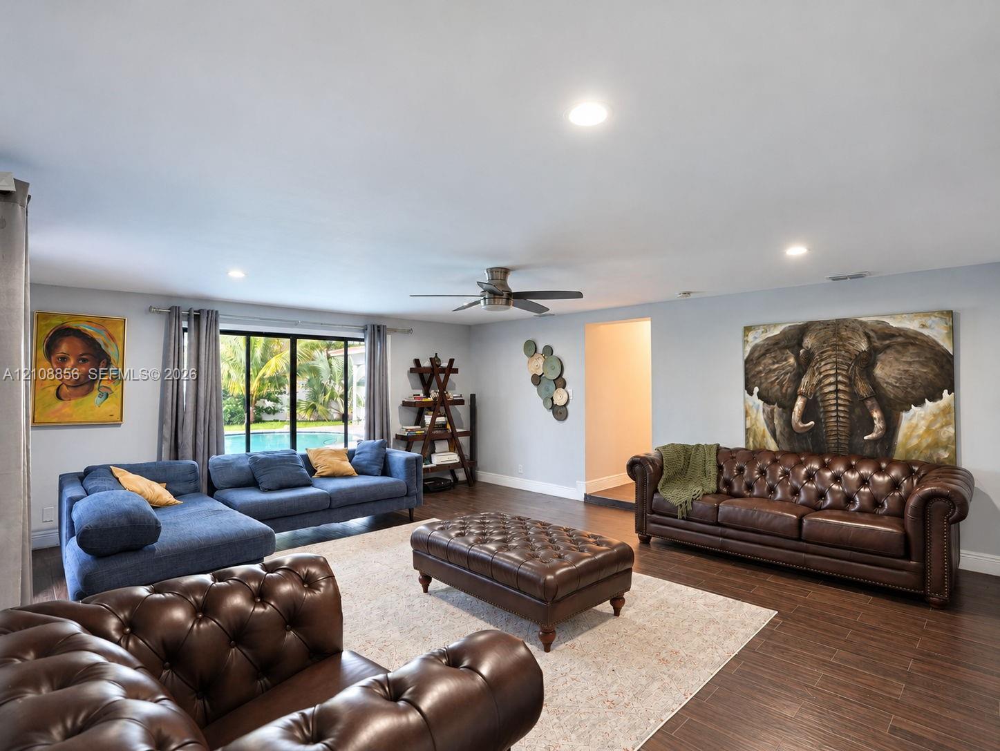 Open-concept living space featuring wood-finish flooring, recessed lighting, and a ceiling fan