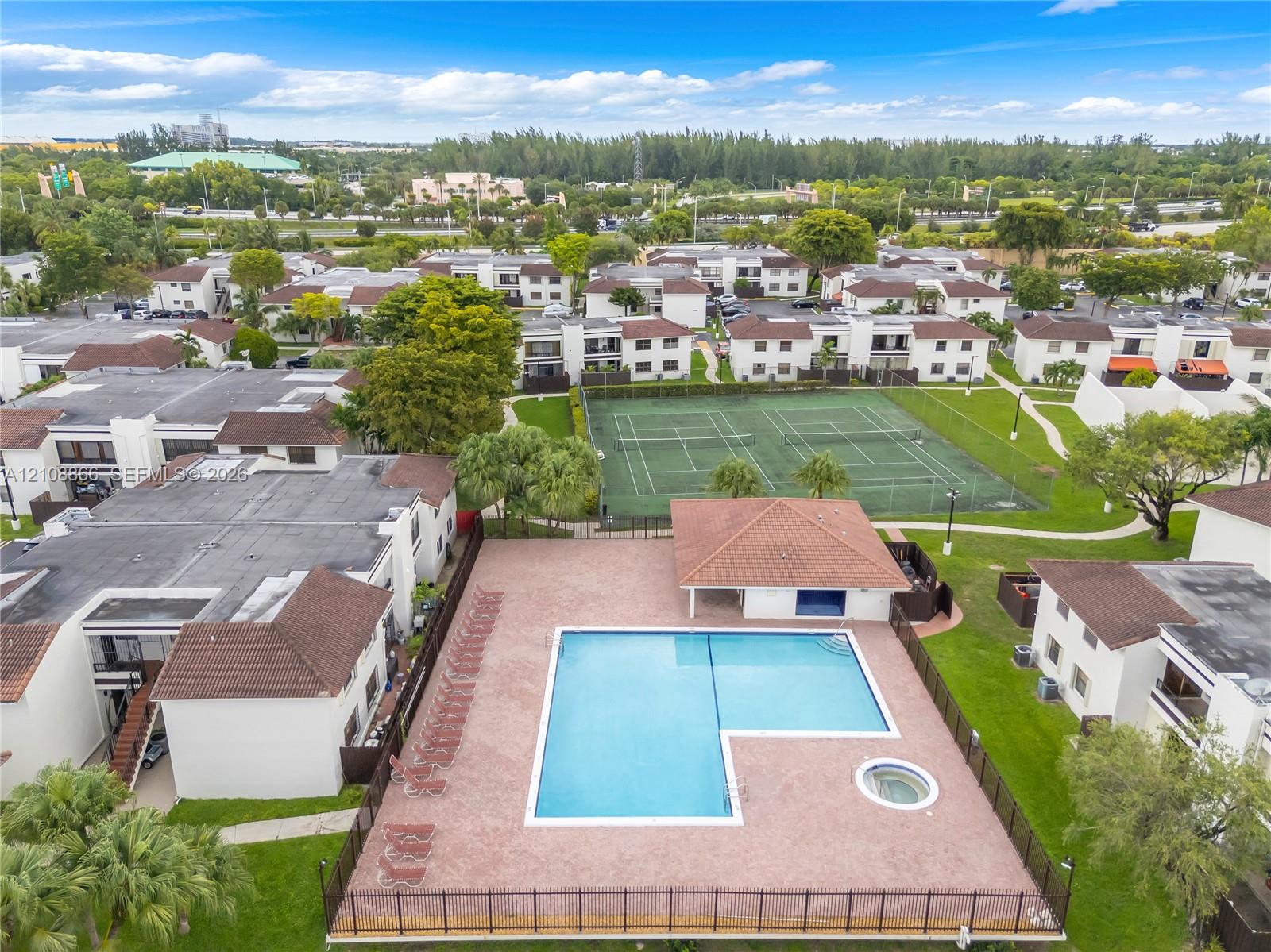 Community recreation area featuring a swimming pool, integrated spa, covered pavilion, and multi-court tennis facility