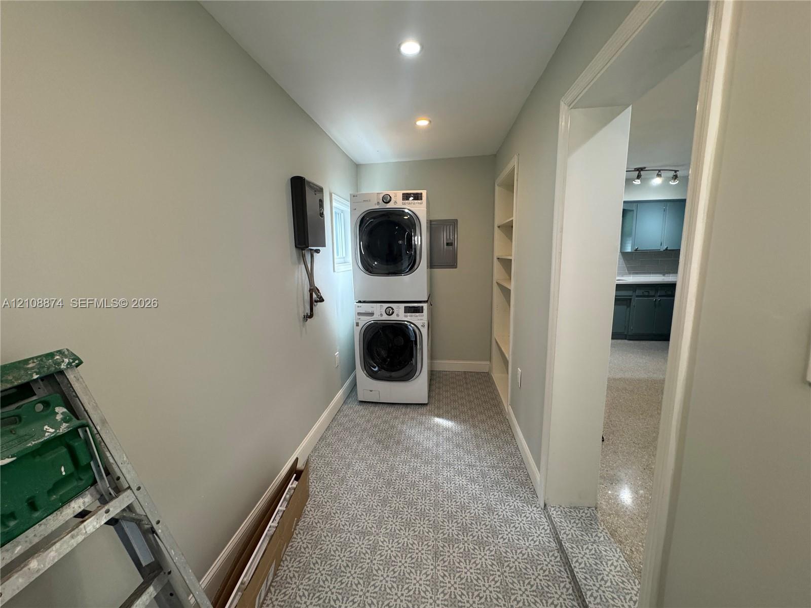 Laundry area featuring patterned tile flooring, built-in shelving, and recessed lighting