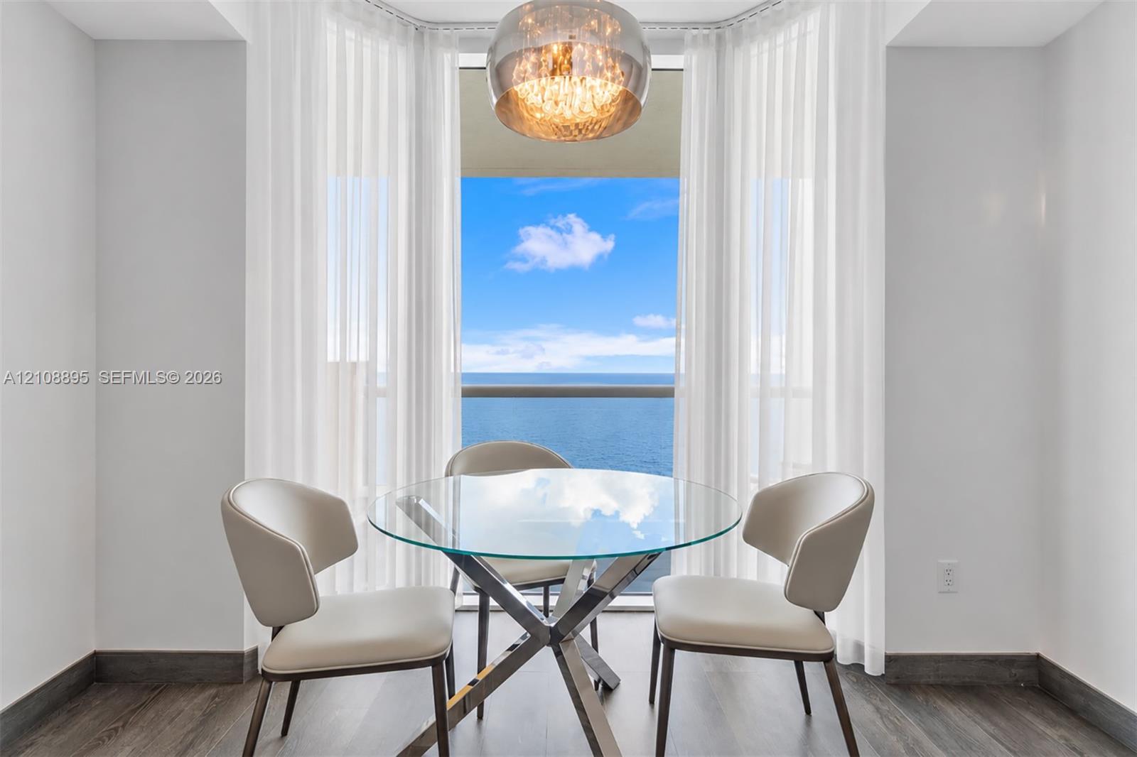 Bay window featuring floor-to-ceiling glass, wood-finish flooring, and a modern spherical pendant light fixture