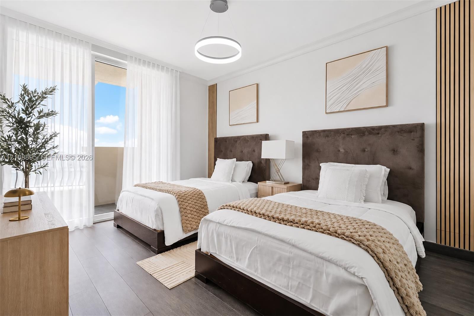 Room featuring wood-finish flooring, floor-to-ceiling glass door, circular pendant lighting, and decorative vertical wall slats