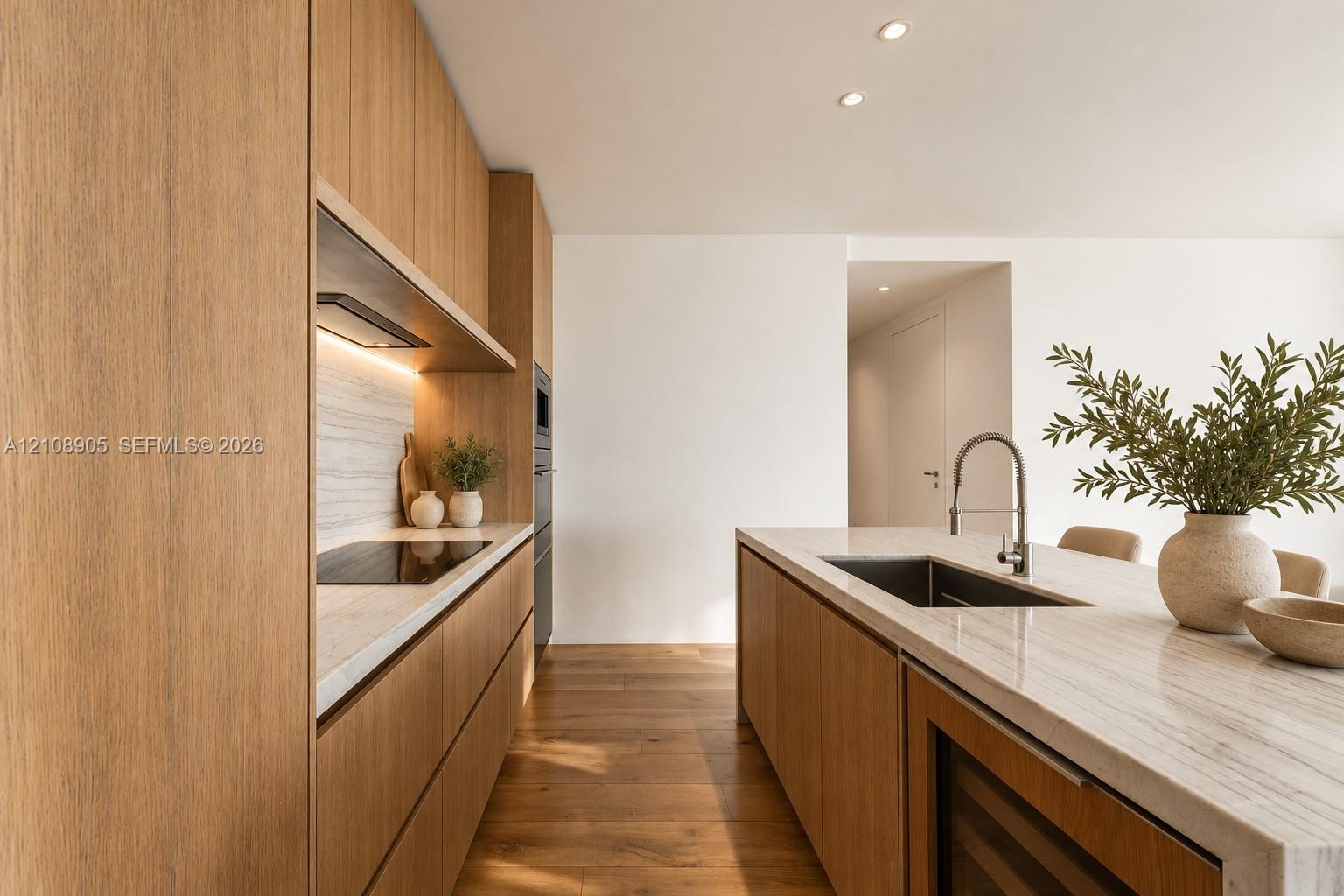 Kitchen featuring custom flat-panel wood cabinetry, integrated stone countertops, recessed ceiling lighting, wood-finish flooring, and built-in under-counter beverage storage