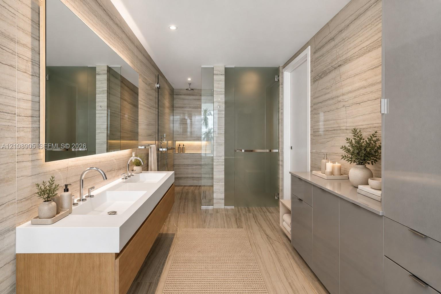 Floating wood-finish double vanity with an integrated countertop, large-format linear wall tile, oversized rectangular mirror with integrated lighting, glass-enclosed shower, and sleek built-in cabinetry