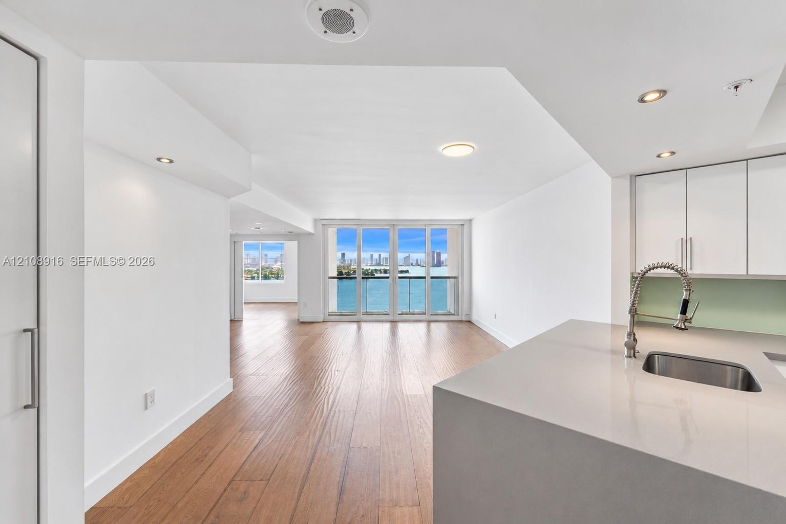 Breathtaking bay views welcome you the moment you enter this stunning residence. The open-concept living space features beautiful hardwood flooring and floor-to-ceiling hurricane-impact glass doors that showcase spectacular panoramic waterfront views.