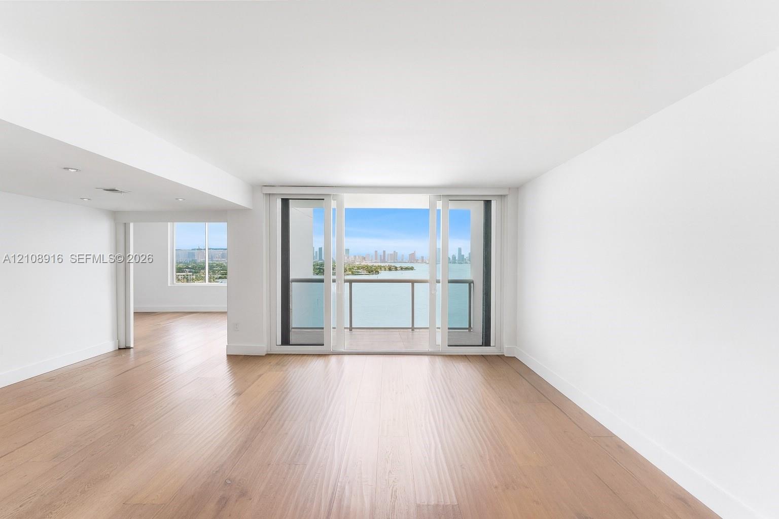 Open-concept living/dining room with balcony access to bay-views.