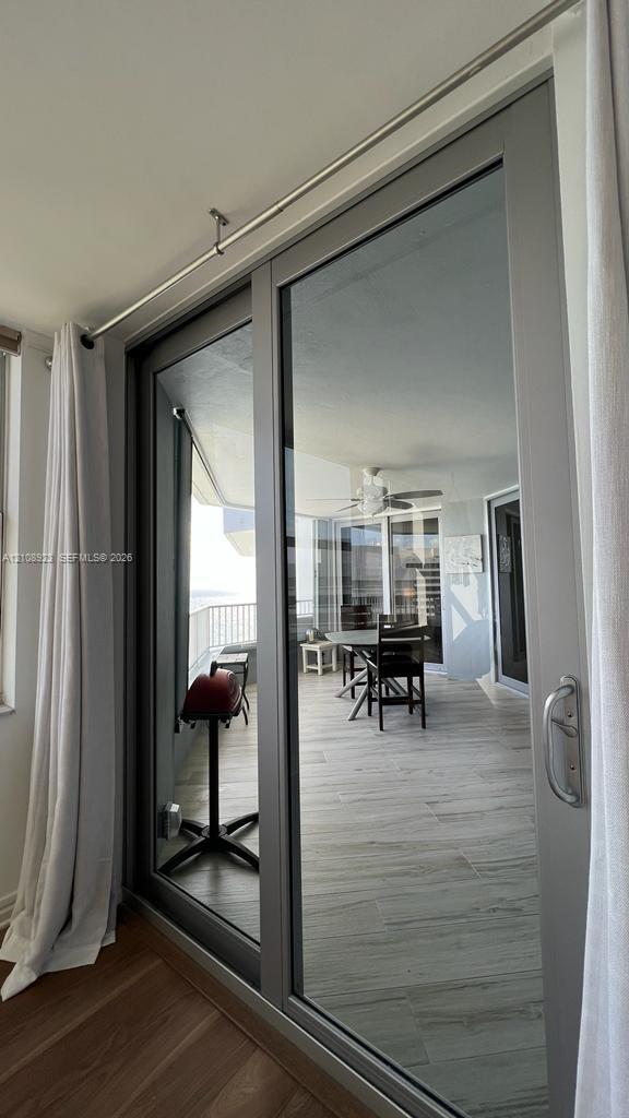 Full-height sliding glass door with a metallic frame and silver hardware, featuring a double-track system