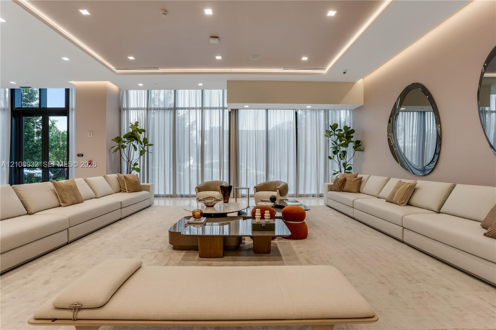 Floor-to-ceiling windows with floor-length drapery, recessed tray ceiling with integrated cove lighting, recessed overhead lighting, and light-toned hard-surface flooring