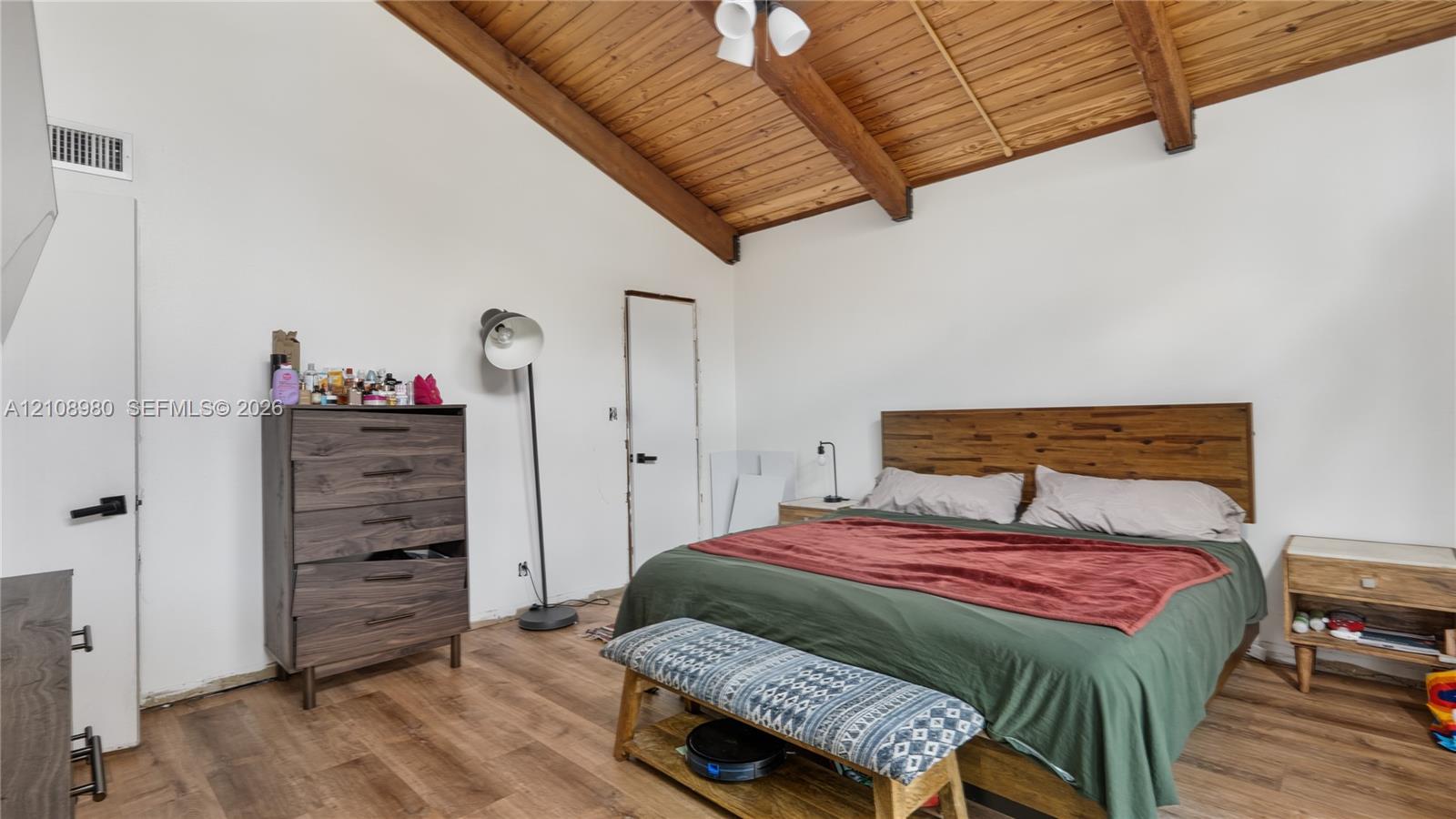 Vaulted wood-plank ceiling with exposed structural beams and wood-finish flooring