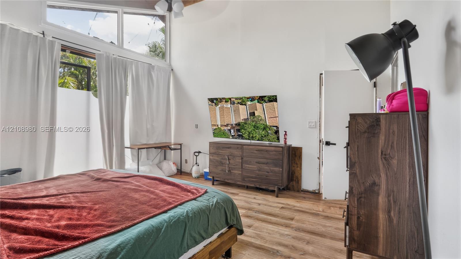 Vaulted ceilings, wood-finish flooring, and high-reaching windows with natural light exposure