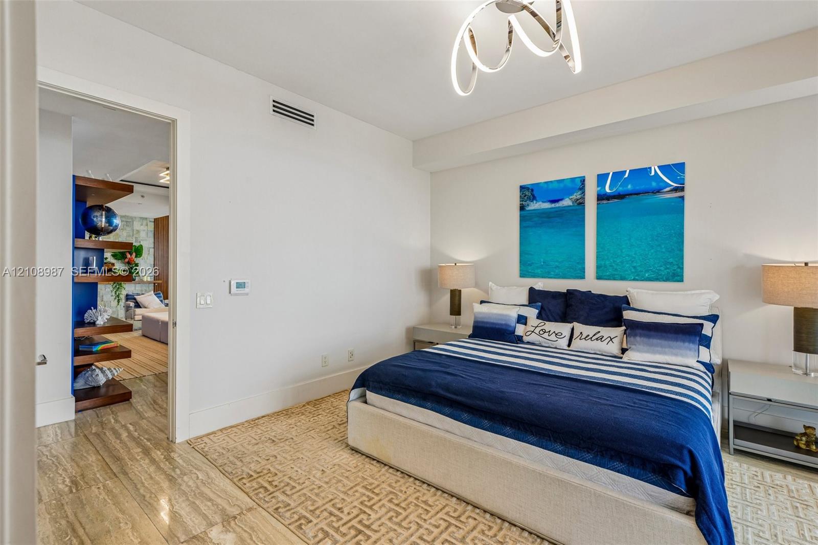 Polished stone flooring, contemporary spiral LED ceiling fixture, and custom built-in wood shelving units