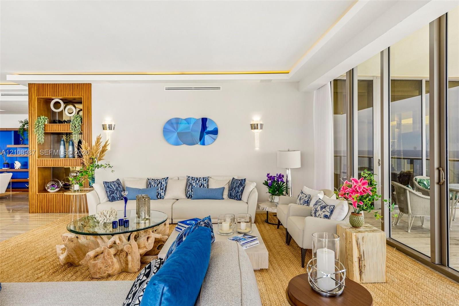 Full-height sliding glass doors, recessed ceiling lighting with crown molding detail, built-in floor-to-ceiling wood shelving, and polished stone-finish flooring Full-height sliding glass doors, recessed ceiling lighting with crown molding detail, built-in floor-to-ceiling wood shelving, and polished stone-finish flooring