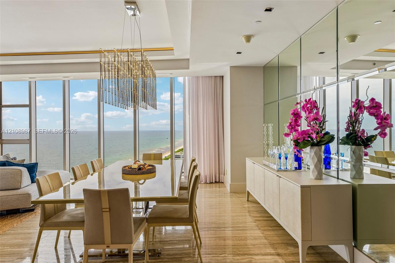 Floor-to-ceiling windows, polished stone flooring, custom mirrored wall paneling, recessed lighting, and a multi-tiered crystal chandelier Floor-to-ceiling windows, polished stone flooring, custom mirrored wall paneling, recessed lighting, and a multi-tiered crystal chandelier