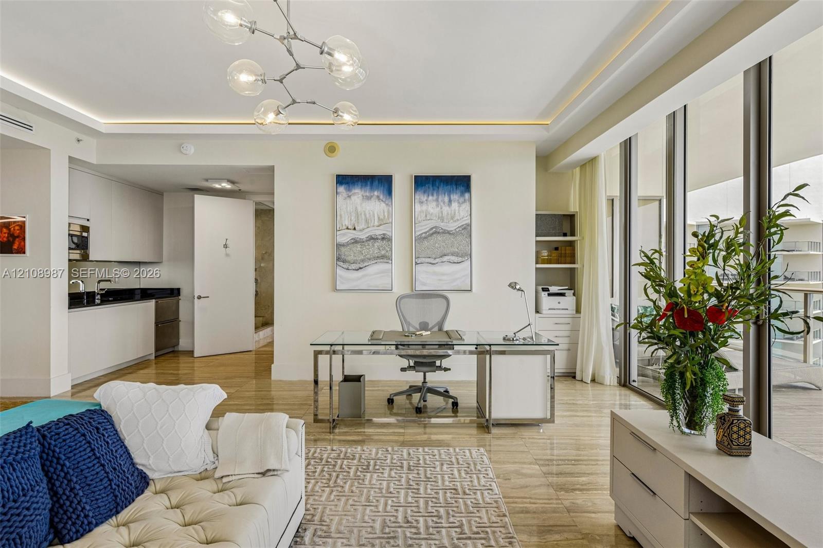 Open-concept interior featuring polished stone flooring, recessed ceiling lighting with integrated trim, a contemporary multi-globe chandelier, and floor-to-ceiling glass panel windows