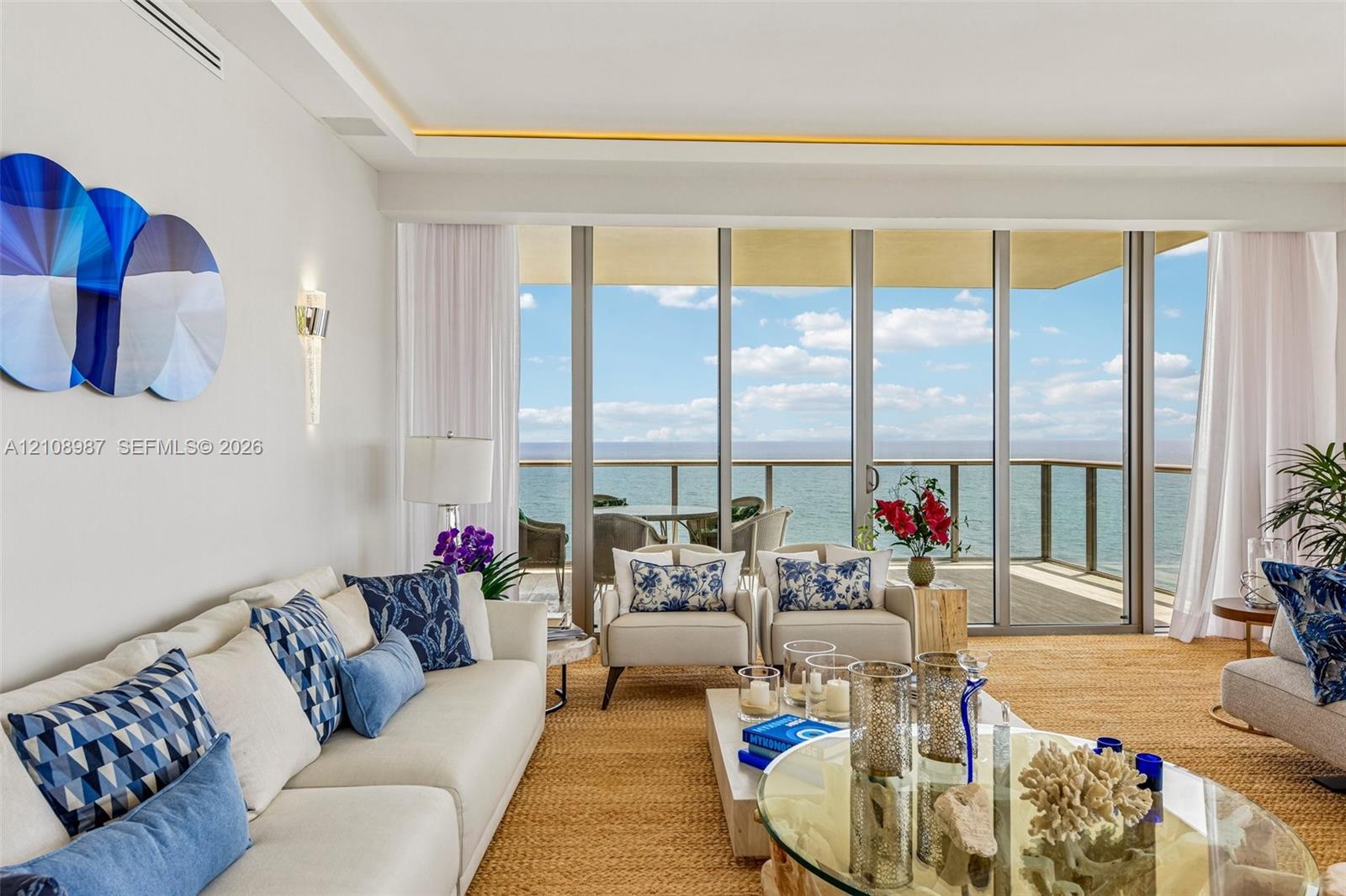 Floor-to-ceiling glass sliding doors, recessed ceiling lighting, wall-mounted sconce, and spacious exterior balcony with metal railing Floor-to-ceiling glass sliding doors, recessed ceiling lighting, wall-mounted sconce, and spacious exterior balcony with metal railing