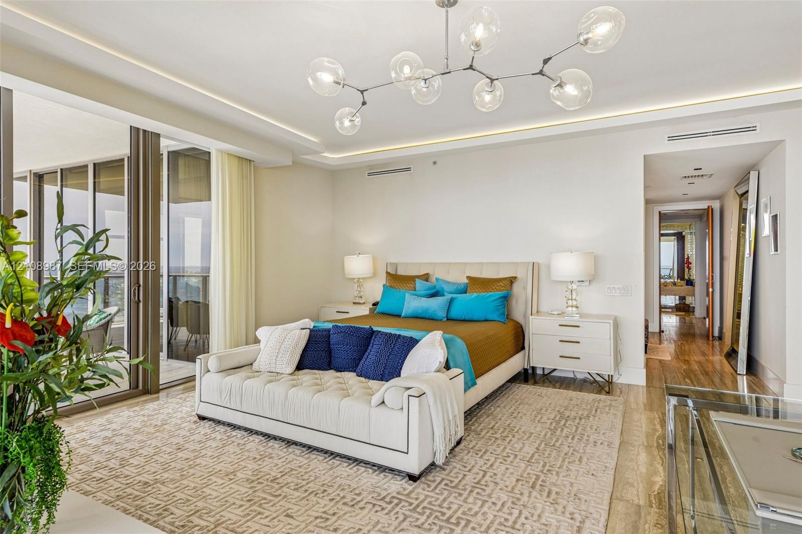 Modern architectural lighting fixture featuring spherical glass shades, floor-to-ceiling glass sliding doors, recessed ceiling lighting, and polished stone-finish flooring