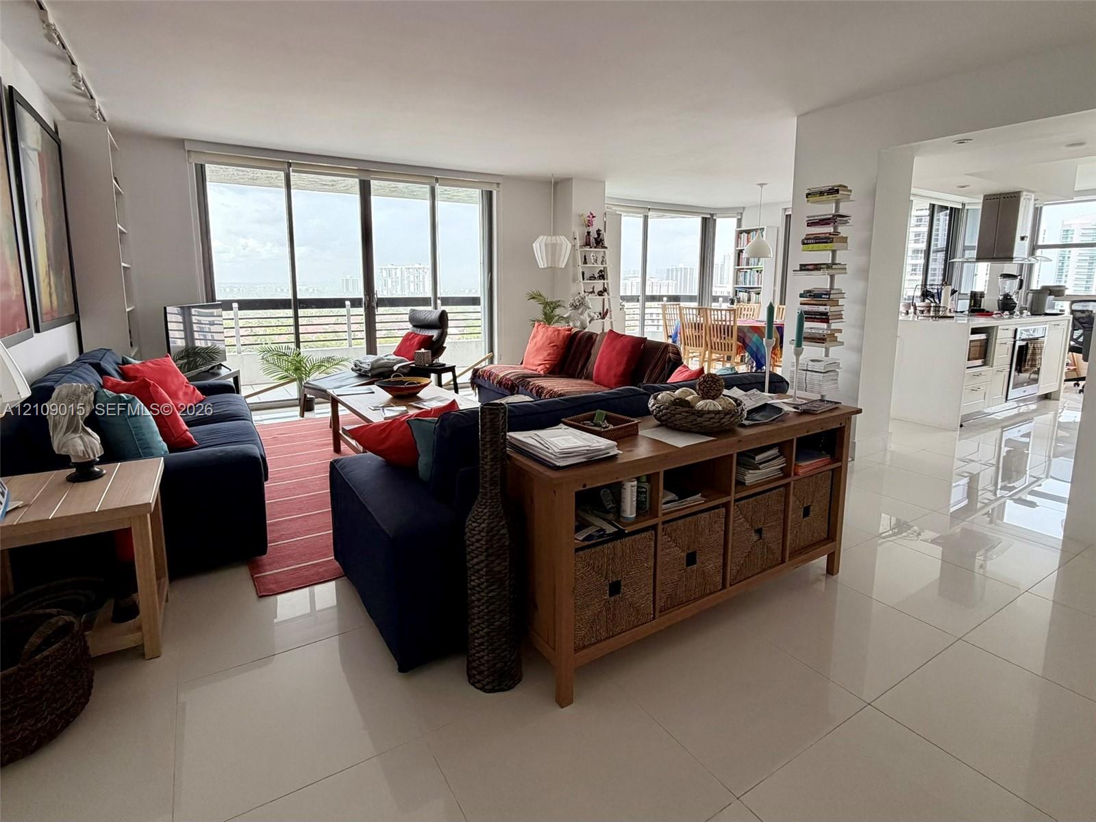 Open-concept interior featuring large-format tile flooring, floor-to-ceiling glass sliding doors, and recessed lighting