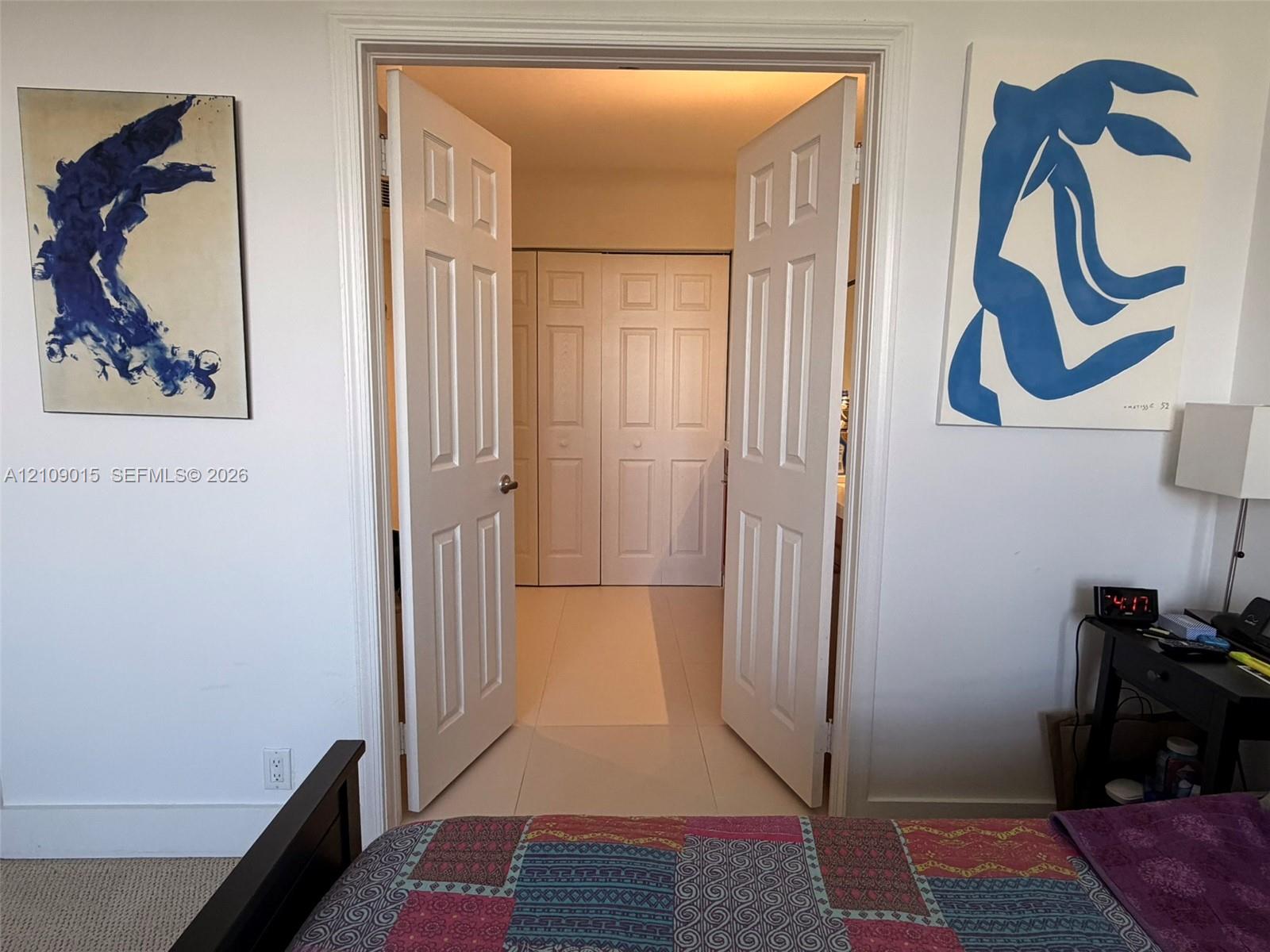 Double-door entry featuring paneled interior doors and a reach-in closet with folding doors