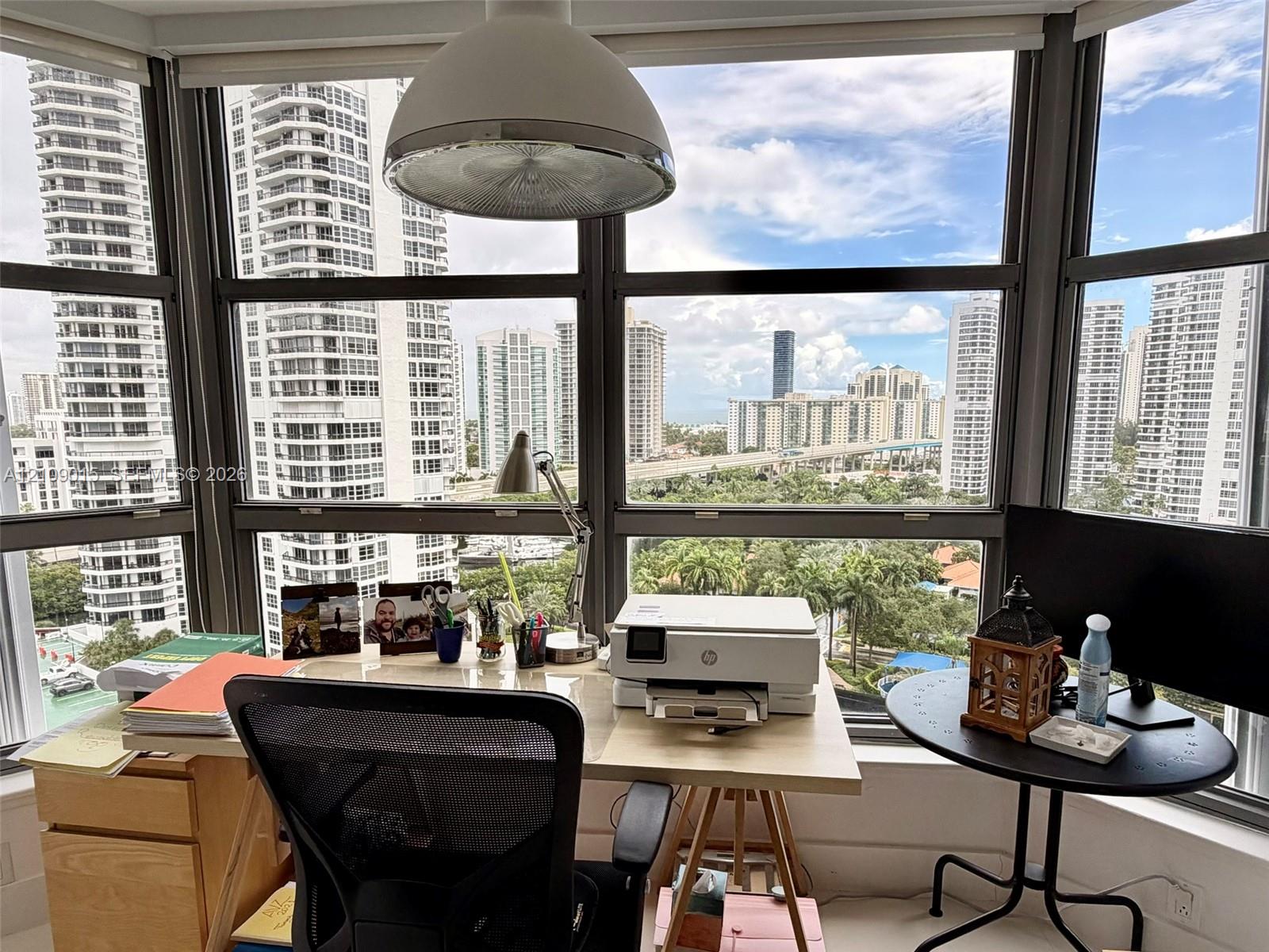 Floor-to-ceiling windows featuring panoramic urban scenery and a dome pendant light fixture