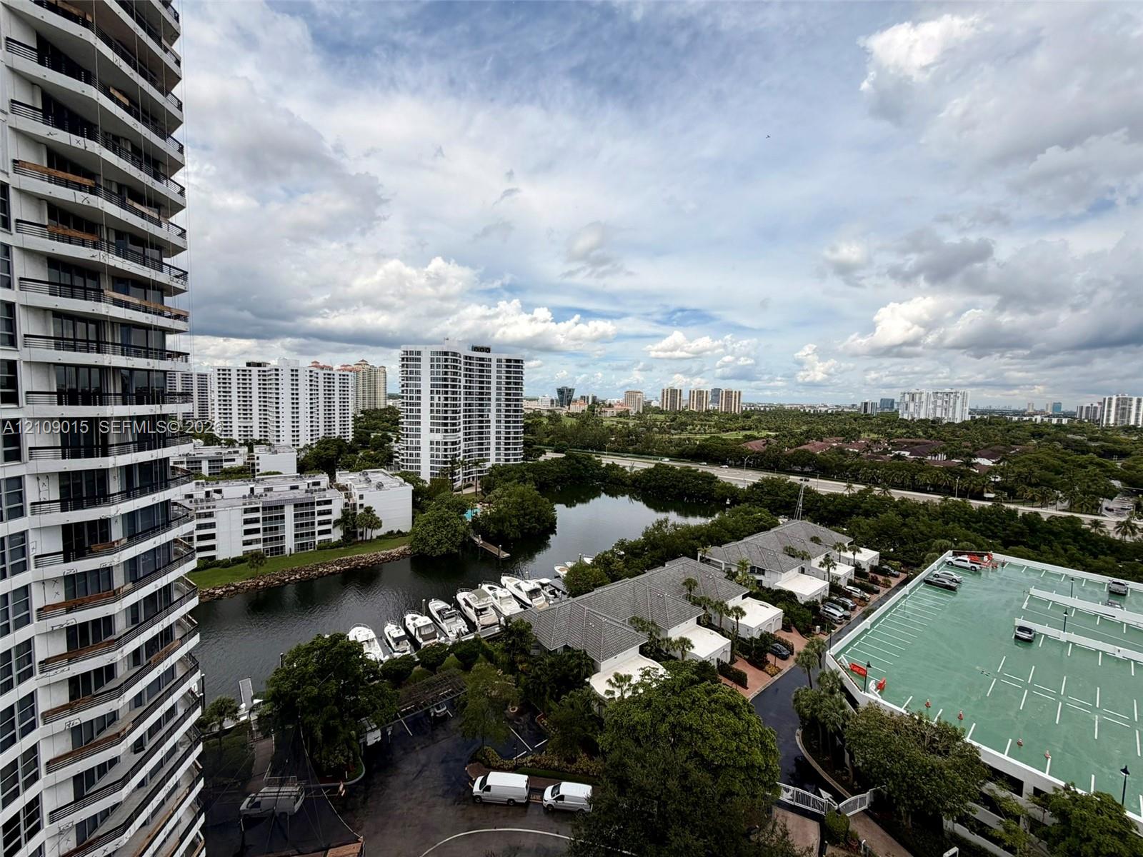 High-rise exterior featuring stacked cantilevered balconies, overlooking a waterway with private boat slips and surrounding residential infrastructure