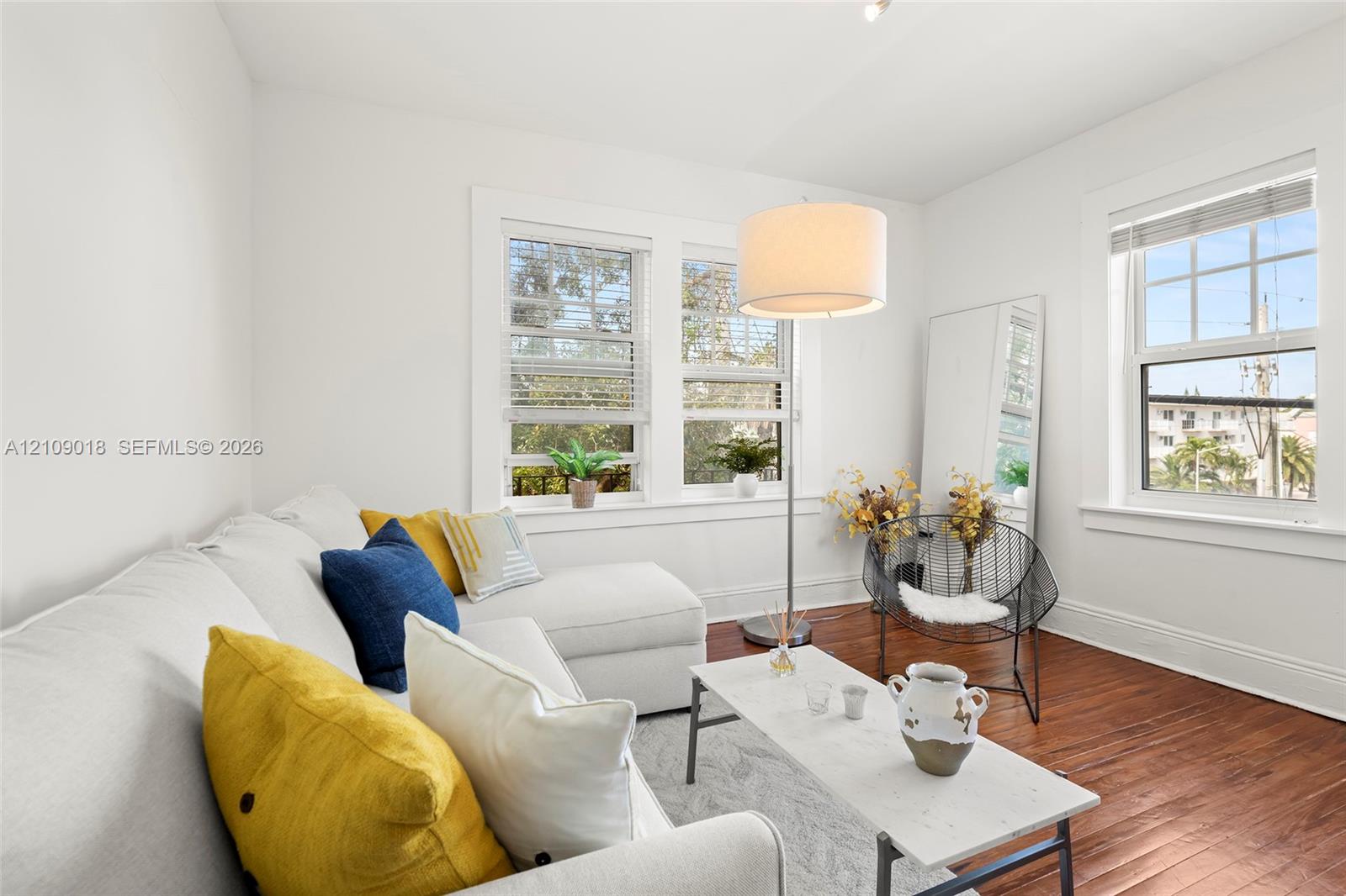 Interior space featuring wood-finish flooring, multi-pane windows, and white wall finishes