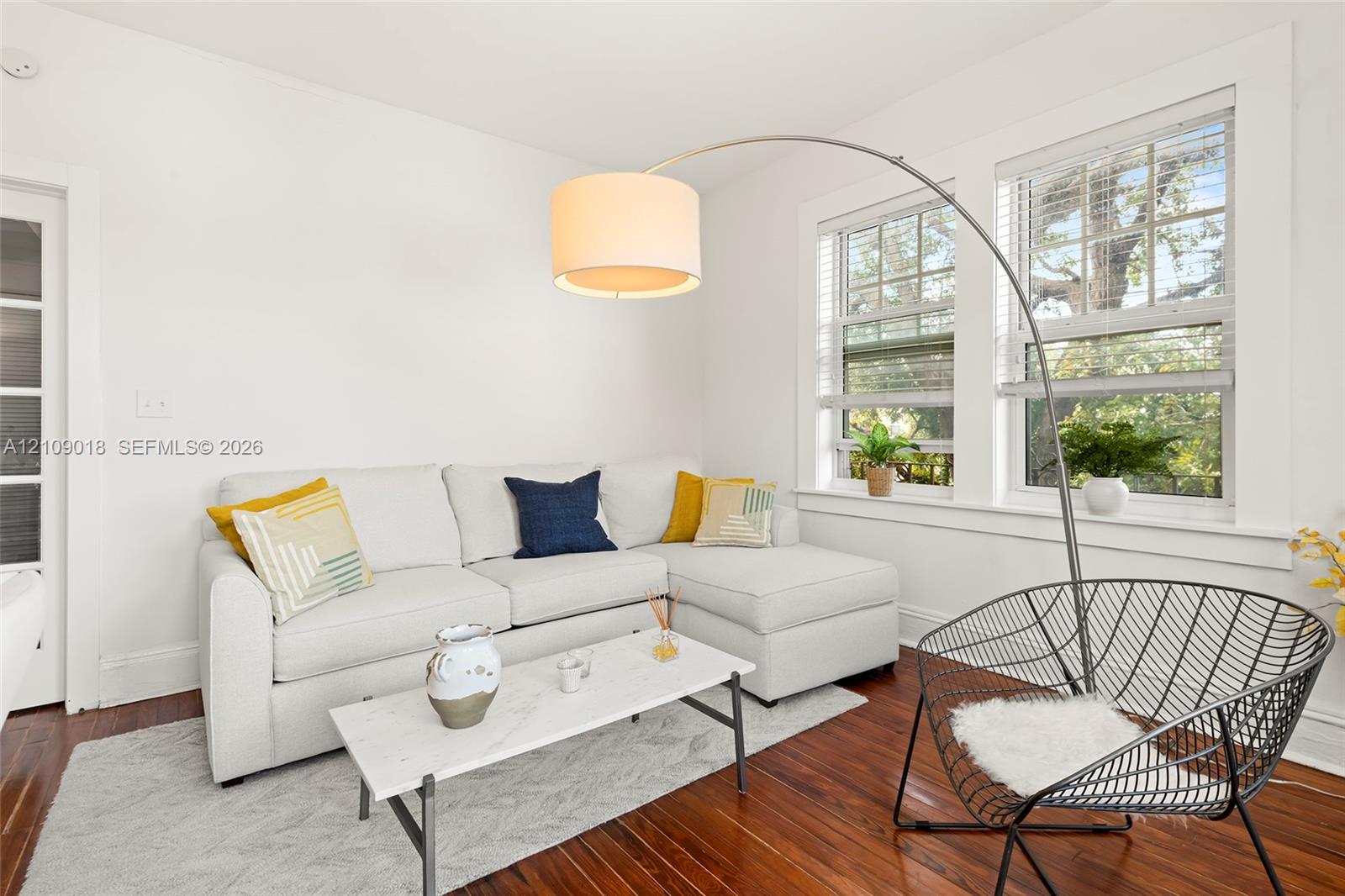 Wood-finish flooring, multi-pane windows with white trim, and a glass-paneled door