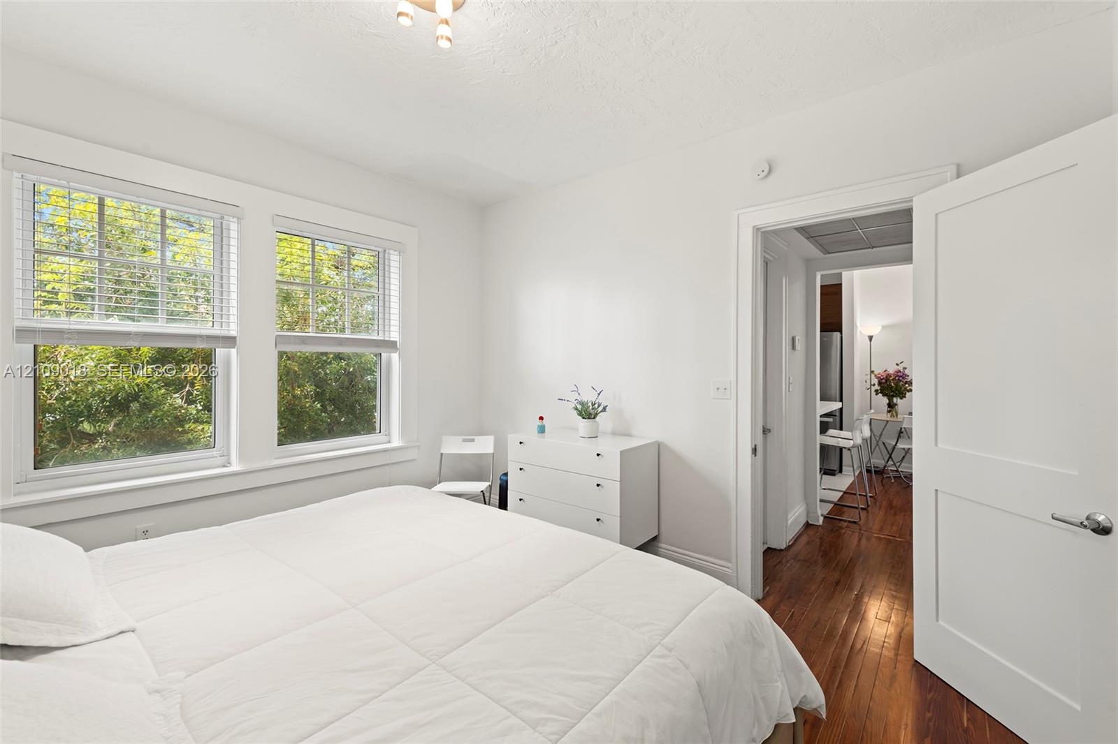 Interior room featuring dual-pane windows, wood-finish flooring, and a solid-core panel door